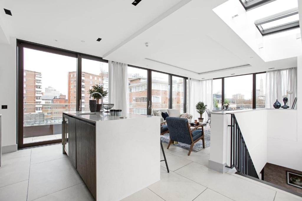 an open kitchen with large windows and a living room at Stunning 3 Bedroom Penthouse Private Terrace AC in London