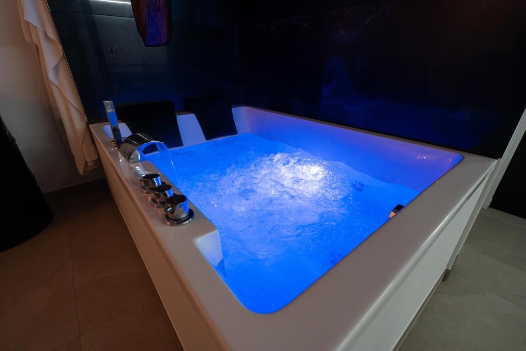 a bathroom sink with blue water in it at Le Saint-André - Clim - Loft romantique avec Jacuzzi in Buxy