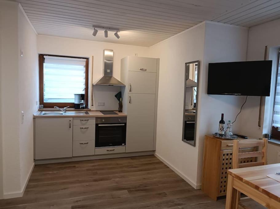 a kitchen with a sink and a tv on the wall at Ferienwohnung in Oberrot in Oberrot
