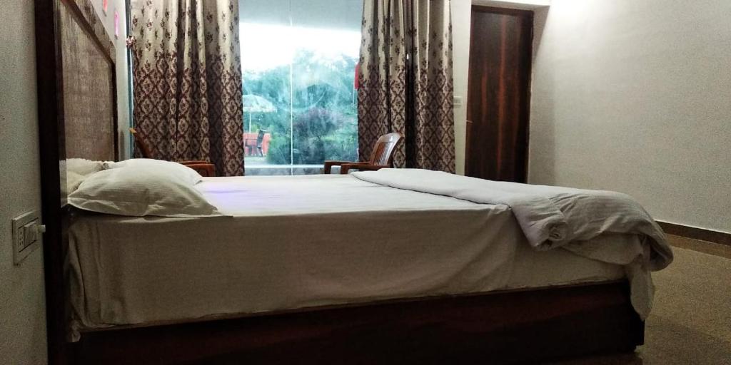 a bedroom with a bed with a window and a mirror at Hotel Radha Rani Mahal in Khajurāho