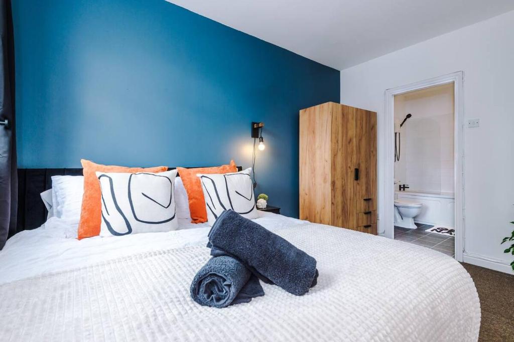 een slaapkamer met een wit bed en een blauwe muur bij Cozy and Stylish 1 Bedroom Flat in Warrington in Warrington