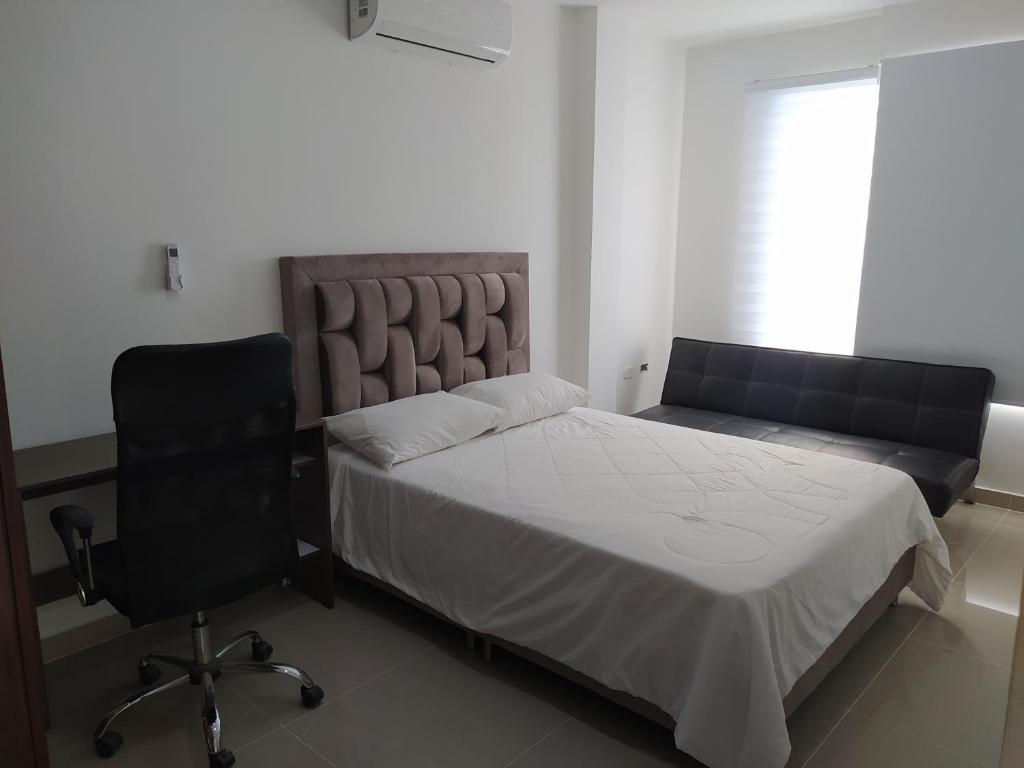 1 dormitorio con 1 cama, 1 silla y 1 ventana en Apartaestudio 201 - Casa Hotel Anita, en Tuluá
