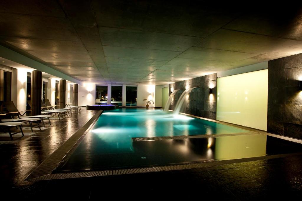 - une grande piscine dans un bâtiment avec une fontaine dans l'établissement Hotel Bonvino Badacsony, à Bytom