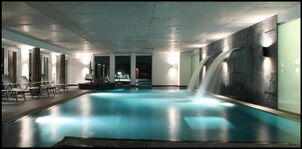 a swimming pool in a hotel with a waterfall at Hotel Bonvino Badacsony in Badacsonytomaj