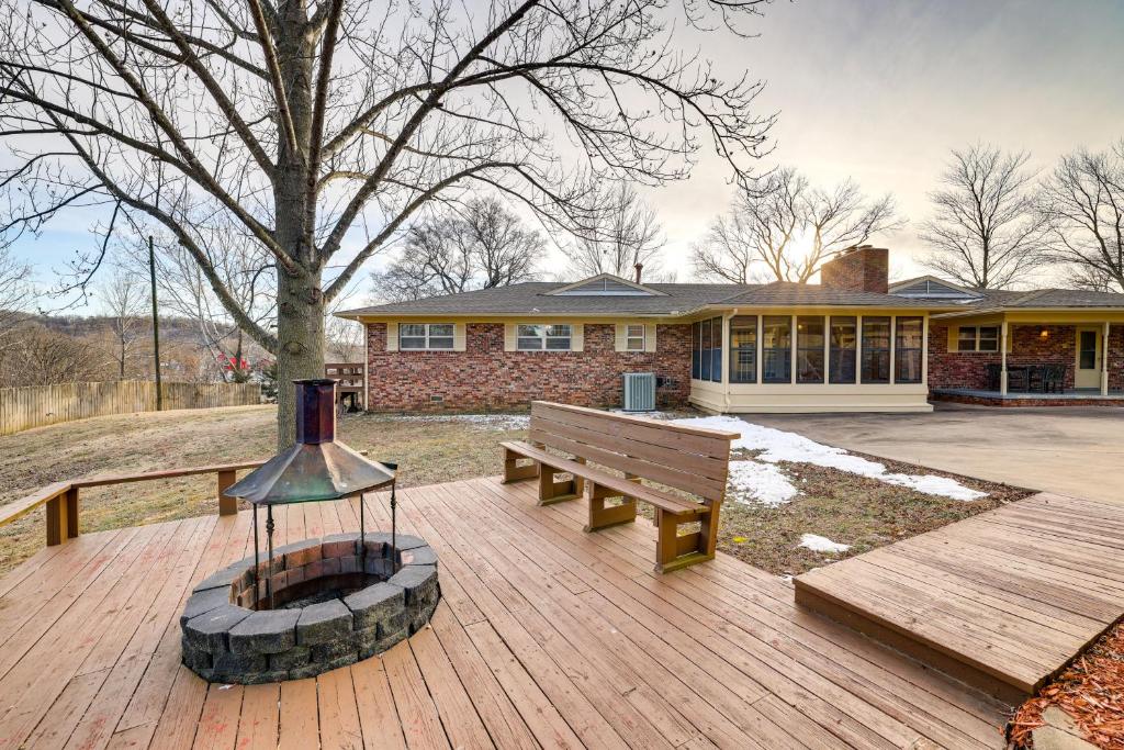 une terrasse en bois avec un banc et une maison dans l'établissement Pineville Home with Fire Pit Less Than Half-Mi to Elk River!, 