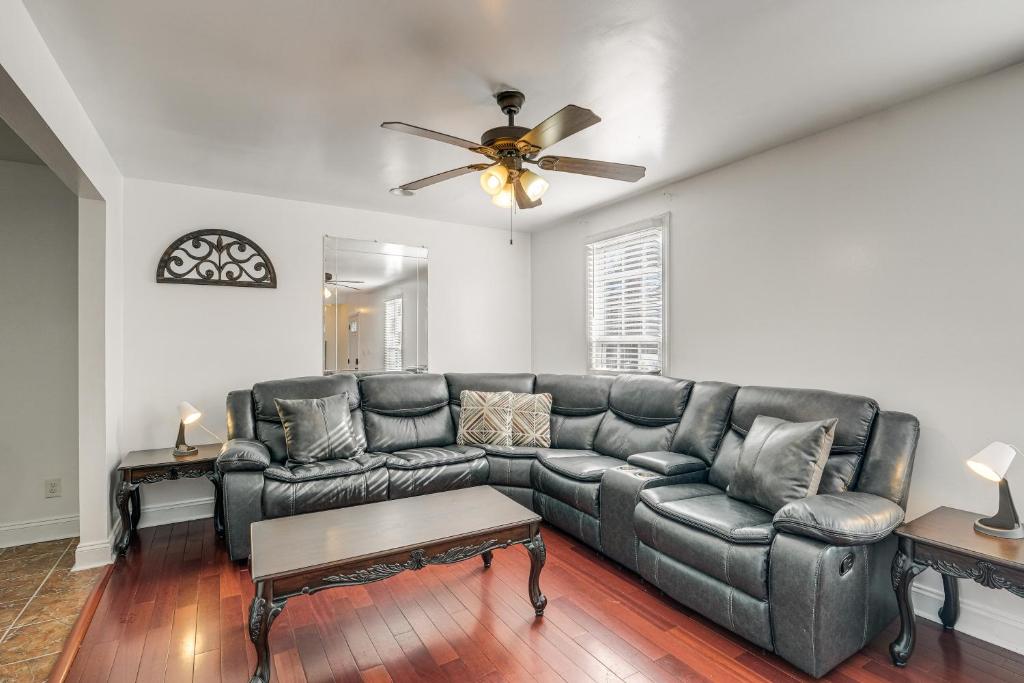 a living room with a leather couch and a ceiling fan at Pet-Friendly Silver Spring Home 2 Mi to Downtown! in Silver Spring