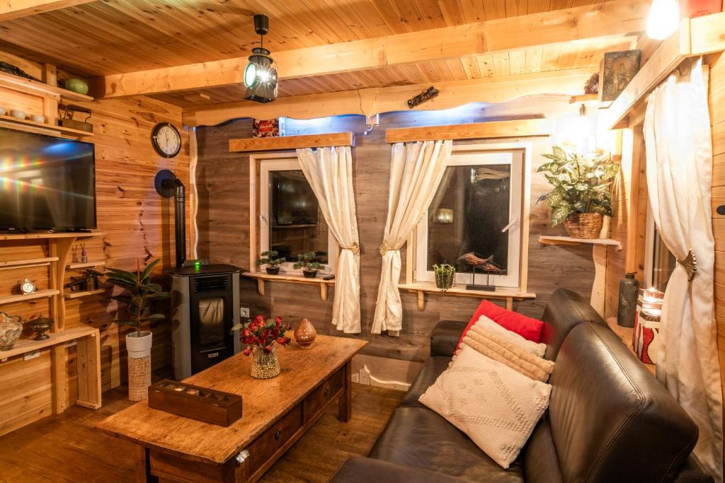 a living room with a couch and a fireplace in a log cabin at Chata Julie in Mařenice