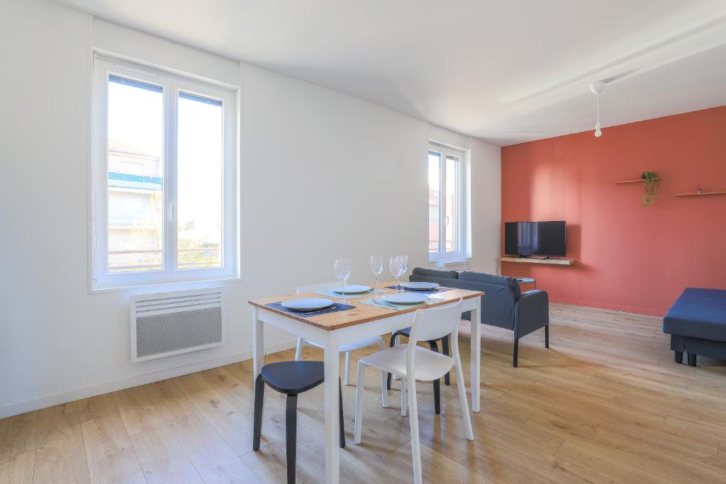 een woonkamer met een tafel en stoelen en een bank bij Appartement Calme - Arras Arrière Gare in Arras
