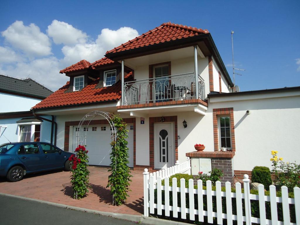 a white house with a white fence and a car at Apartment Duhová in Františkovy Lázně