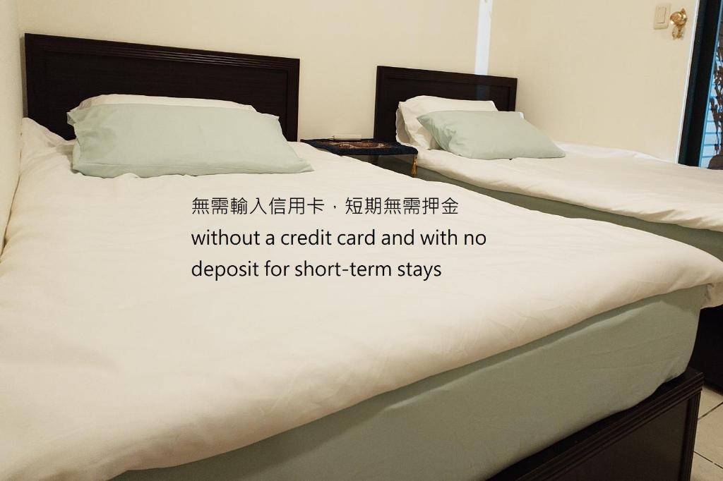 two beds in a room with a sign on the bed at Cat5 Mewo Meow House in Taipei