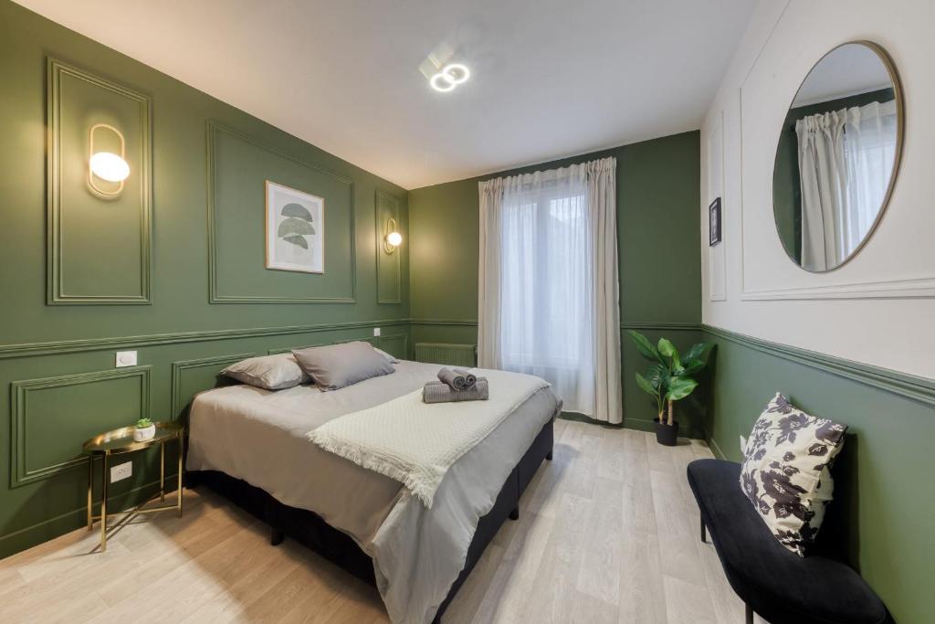 ein Schlafzimmer mit grünen Wänden, einem Bett und einem Stuhl in der Unterkunft Charming accommodation - Close to Paris in LʼÎle-Saint-Denis