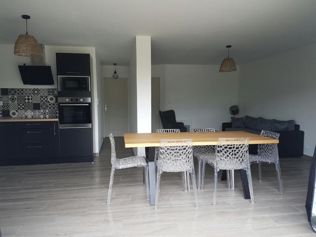 a dining table and chairs in a living room at La Perle de Dolitéma in Grues