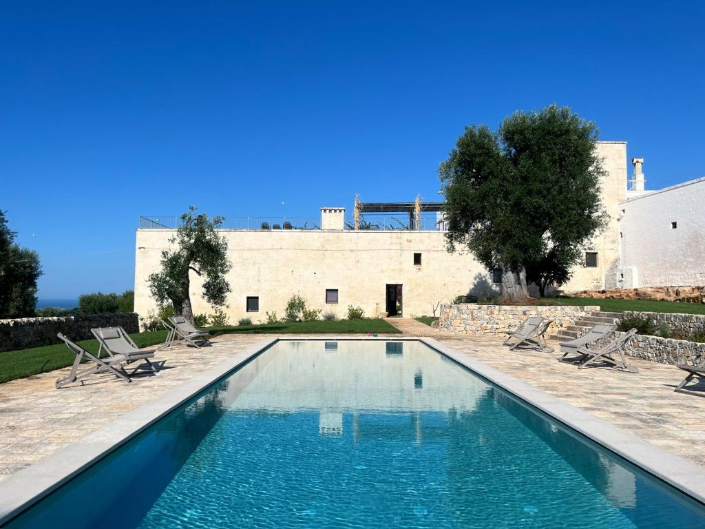 una piscina di fronte a un edificio di Masseria Morrone a Ostuni