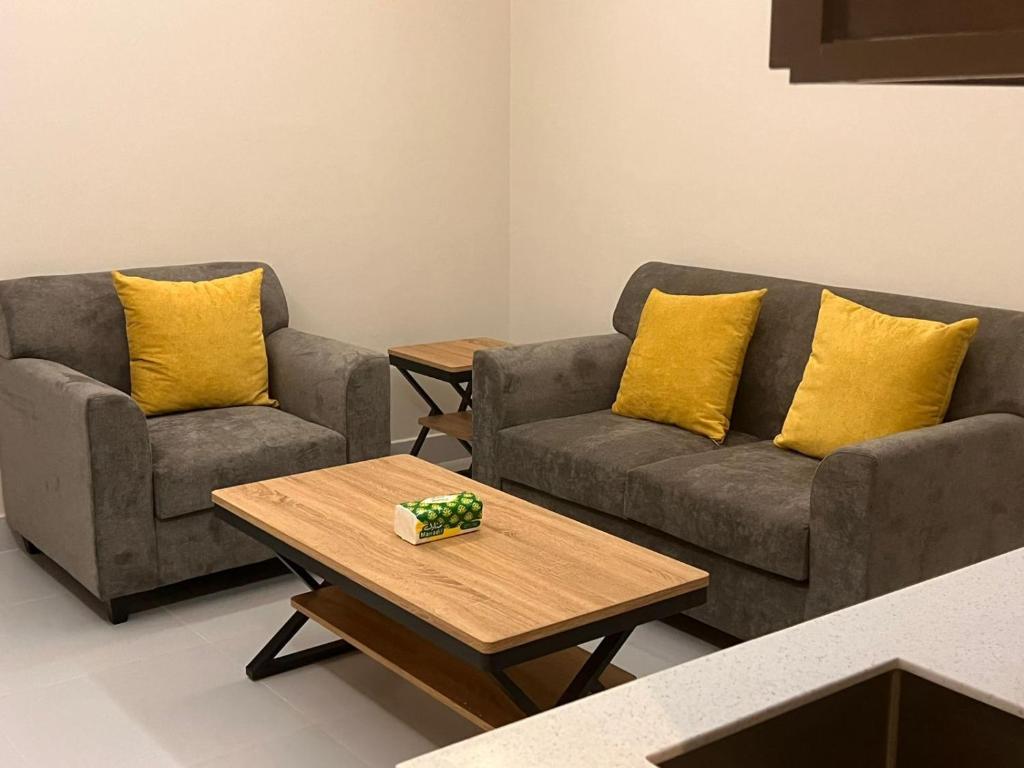 ريزا الفندقية Reeza Suites في الخبر: غرفة معيشة مع كنبتين وطاولة قهوة