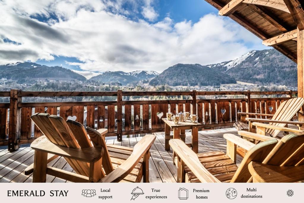 a deck with chairs and tables with mountains in the background at Chalet Heavenly Morzine - by EMERALD STAY in Montriond