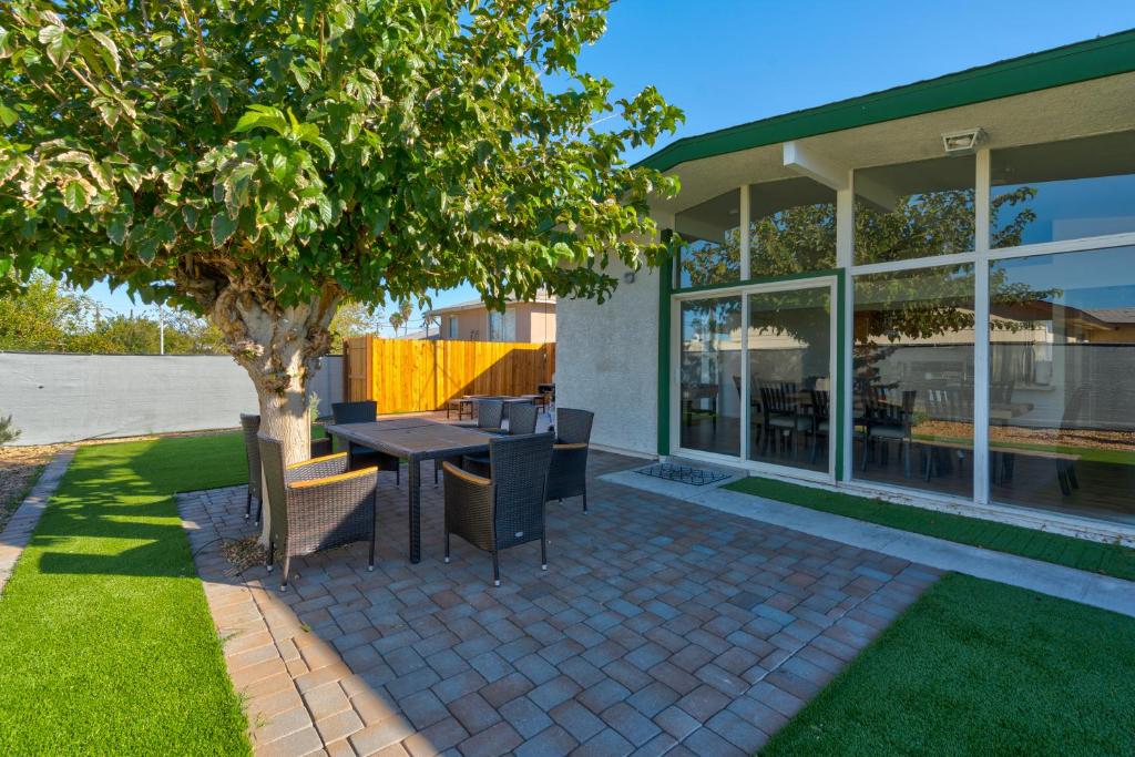 a patio with a table and chairs under a tree at Spacious Remodeled Retreat Haven in Las Vegas