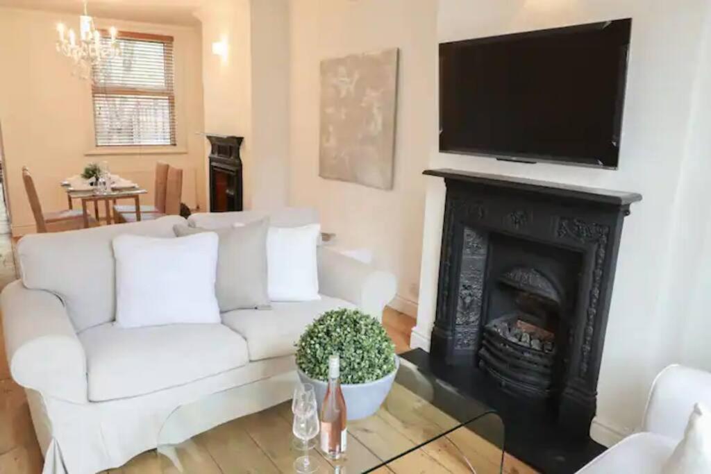 a living room with a white couch and a fireplace at Charming 2-Bed in Windsor: Walk to all the sites! in Windsor