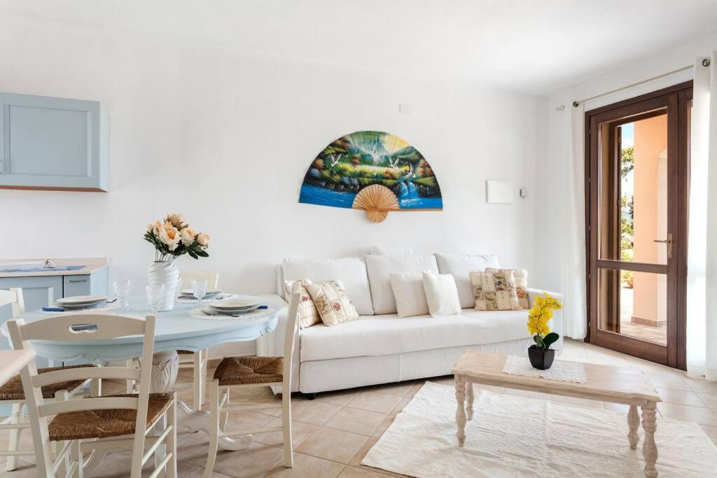 Villa Hermosa في Telti: غرفة معيشة مع أريكة بيضاء وطاولة