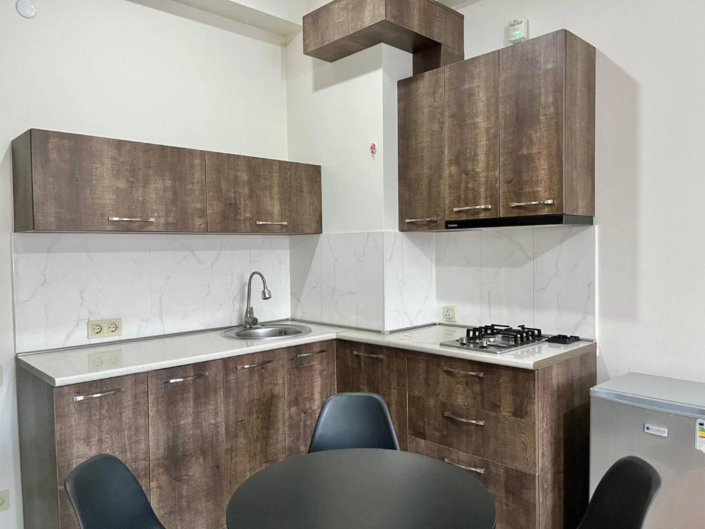 a kitchen with wooden cabinets and black chairs in it at Heven of Chilovski in Filipów