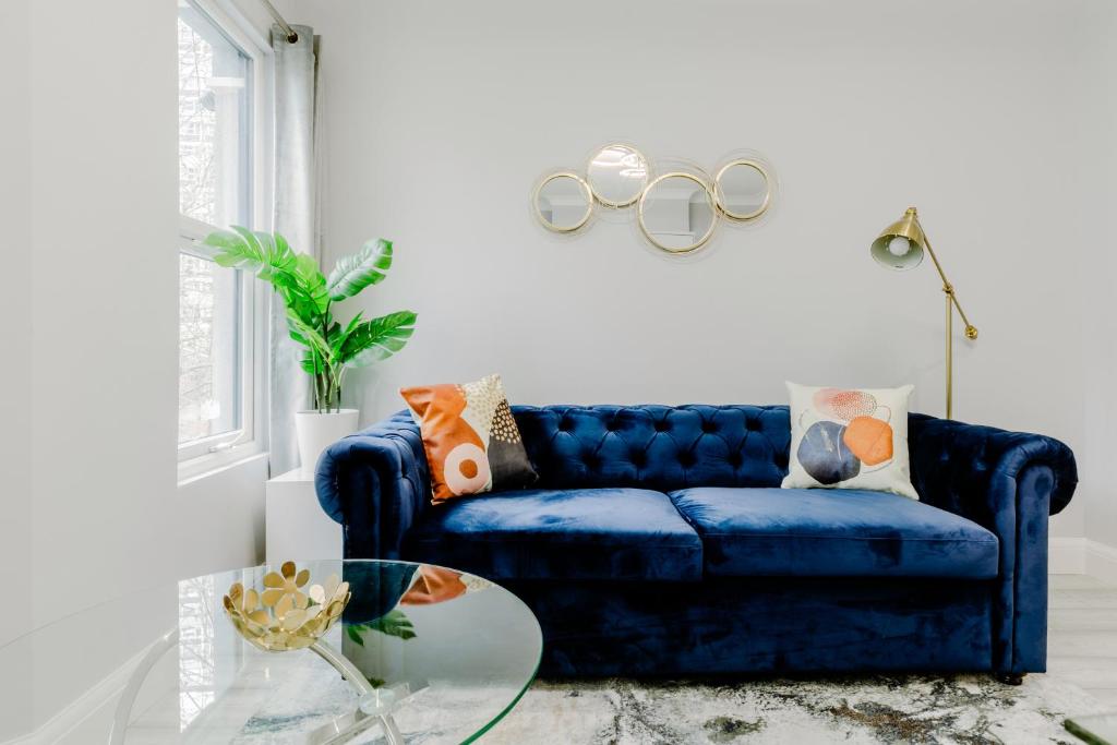 Sofá azul en la sala de estar con mesa de cristal en Homely 3 Bedroom House in Hammersmith, en Londres
