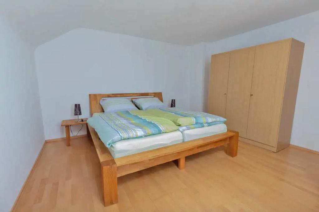 Höfen的住宿－Ferienwohnung Biebes，一间卧室配有一张床和一个橱柜