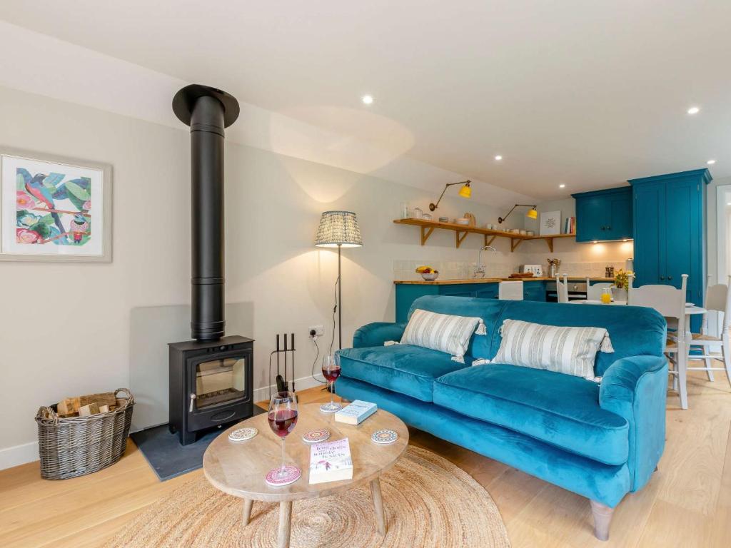a living room with a blue couch and a stove at 1 Bed in Sherborne 83499 in Wincanton