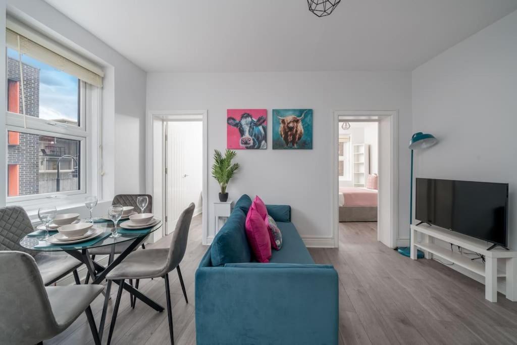 uma sala de estar com um sofá azul e uma mesa em Spacious 2bed Brick Lane flat - 2nd Floor em Londres