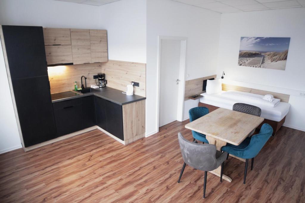 a room with a kitchen and a table and a bed at Hive Apartments - direkt an der Hannover Messe in Hannover