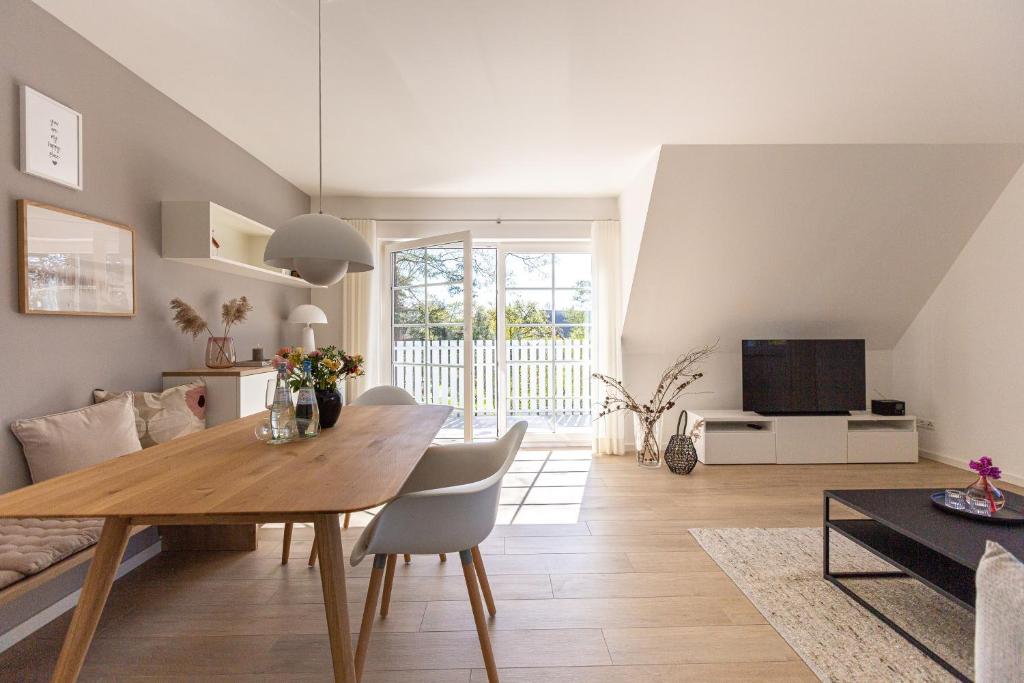 a dining room and living room with a wooden table at Lieblingsplatz in Born