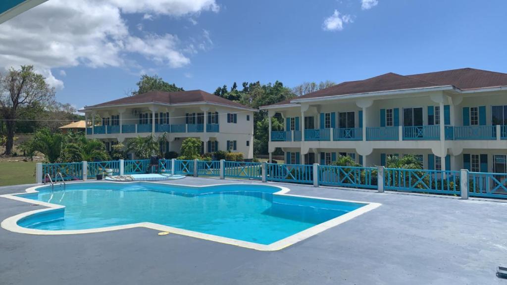 a large house with a swimming pool in front of it at The Resort at West End in Negril