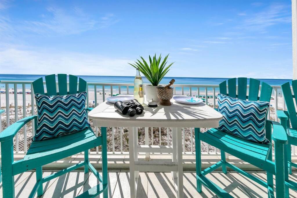 a table and two chairs on a balcony with the ocean at Gulf Dunes 506 Hello Sunshine in Fort Walton Beach
