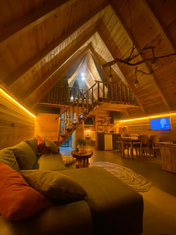 a living room with a couch and a staircase at Luna Bungalov in Rize