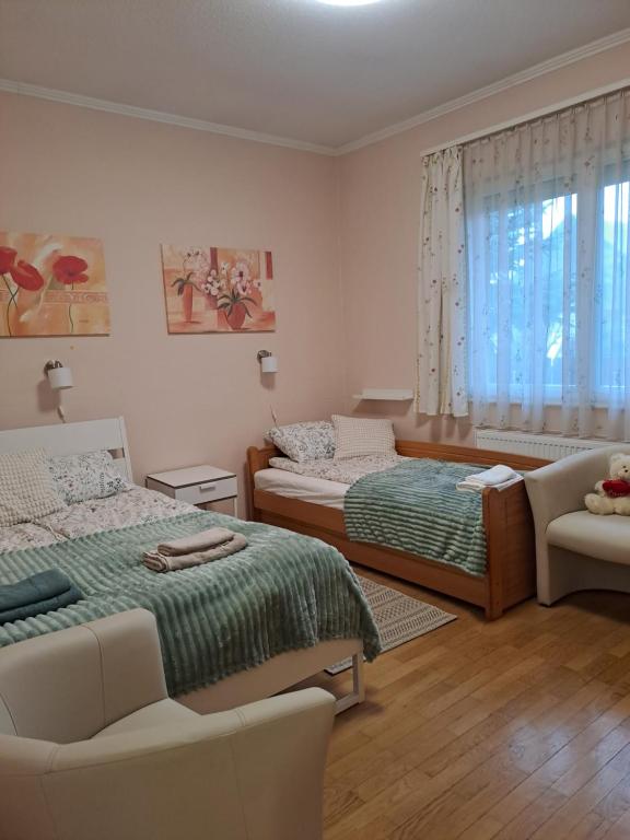 um quarto com 2 camas e um sofá em Lena apartment - Lena two bedroom apartment em Vecsés