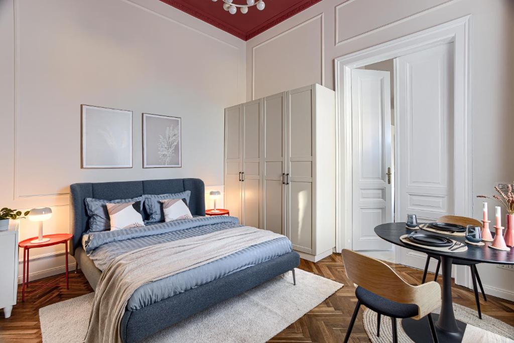 a bedroom with a bed and a table with chairs at City Center Art Apartment in Arad