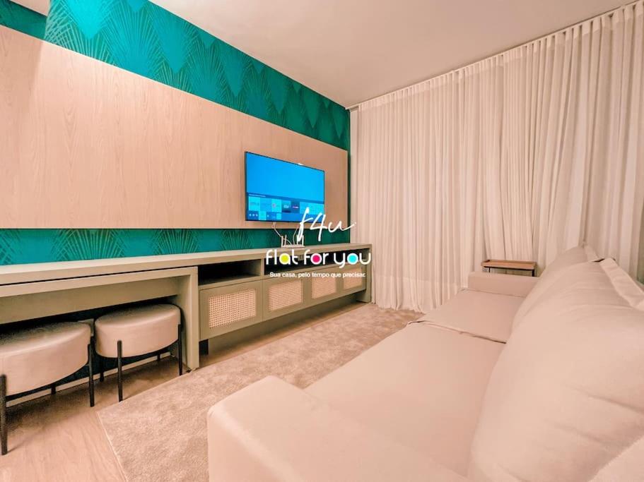 - un salon avec un canapé blanc et une télévision dans l'établissement #953A# Lindo Apê 1Q St. Marista, à Goiânia