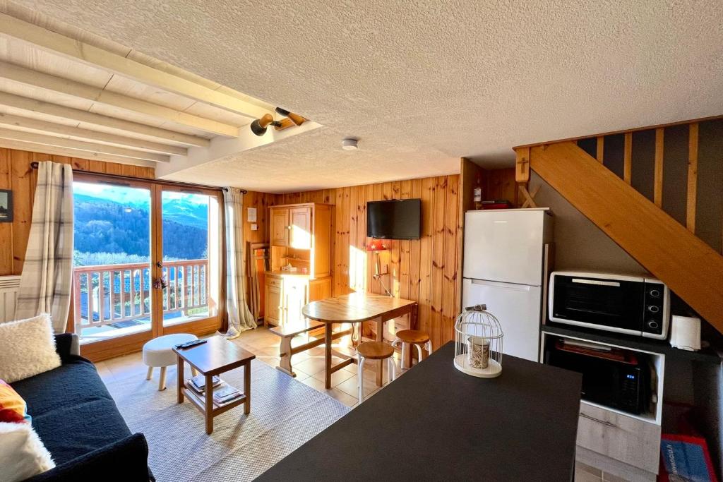 a kitchen and living room with a table and a refrigerator at Apartment with balcony and exceptional view in Saint-Gervais-les-Bains