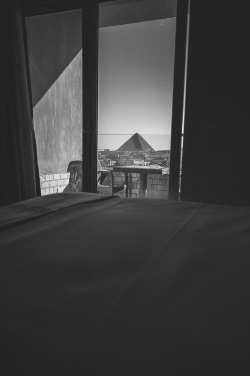 Postel nebo postele na pokoji v ubytování WOW Pyramids Inn With Rooftop Lounge