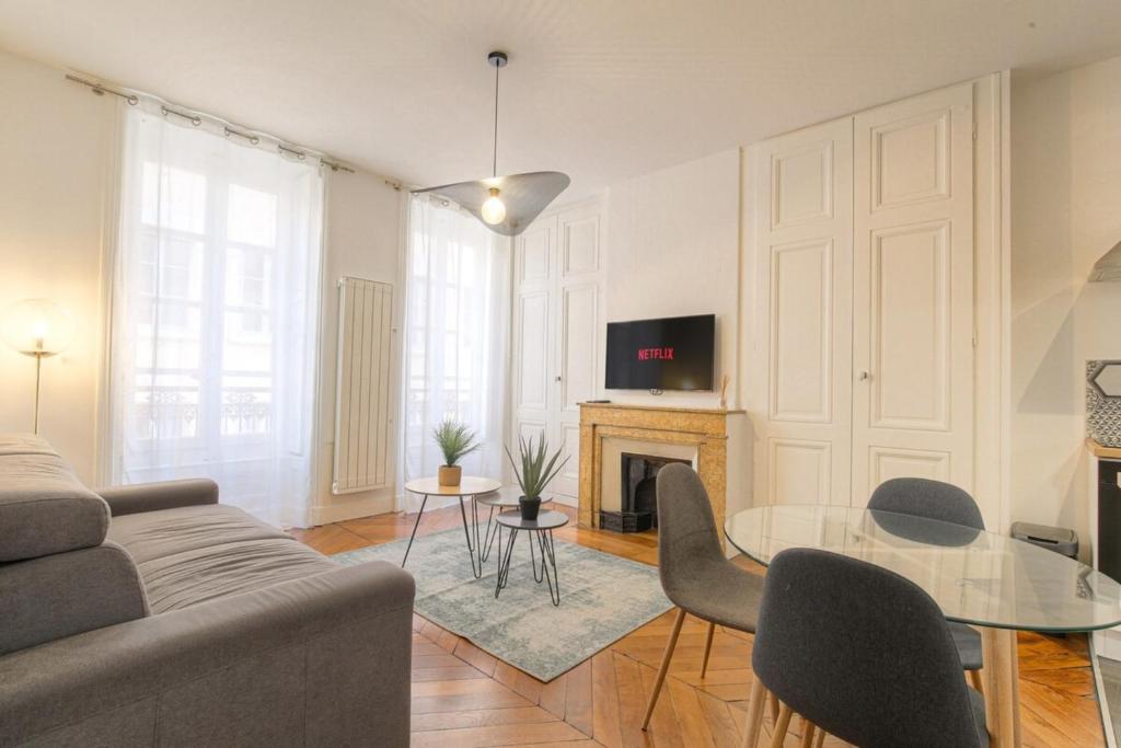 un salon avec un canapé et une table dans l'établissement Caractère et Charmant en Hypercentre, à Lyon