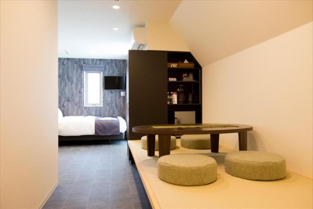 a room with a table and two stools and a bed at CHA-AN UENO Hotel Ueno - Vacation STAY 74227v in Tokyo