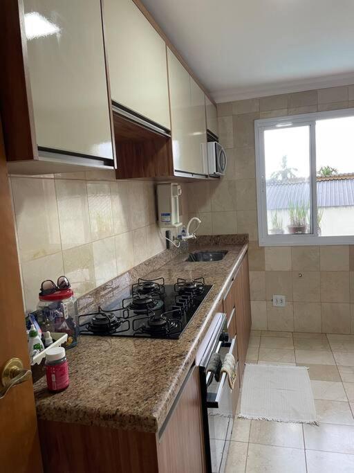 a kitchen with a stove and a counter top at Apto mobiliado, 50 metros da praia. in Angra dos Reis