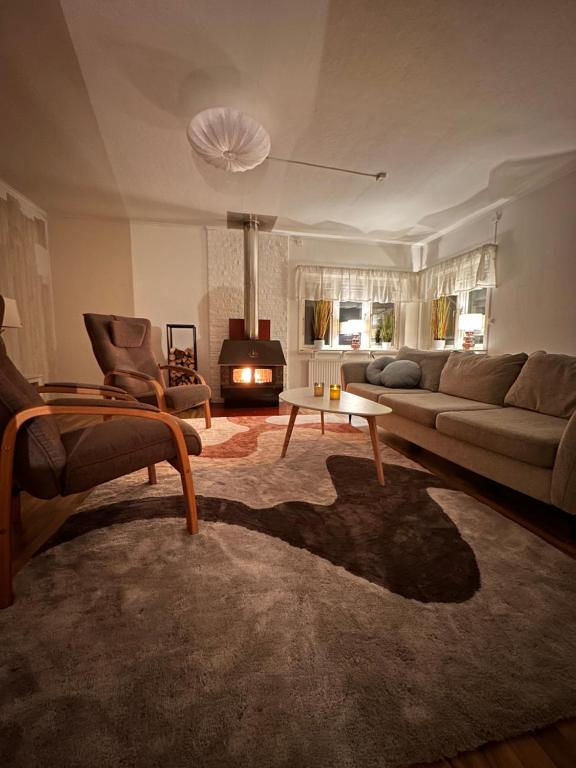 un soggiorno con divano e camino di Cozy guesthouse in Slussfors, Swedish Lapland a Slussfors