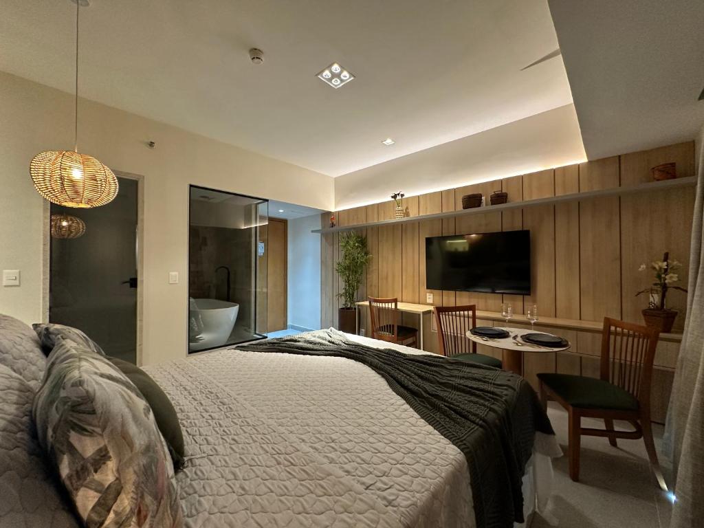 Studio de Luxo com vista deslumbrante para o Rio في ماناوس: غرفة نوم بسرير وحمام مع حوض استحمام