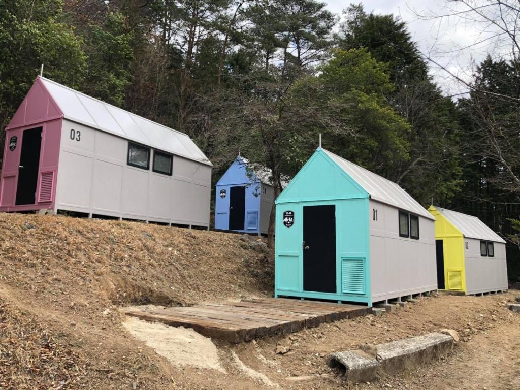 uma fila de cabanas coloridas sentadas no topo de uma colina em Iiji Tent Mura - Camp - Vacation STAY 76594v em Ena