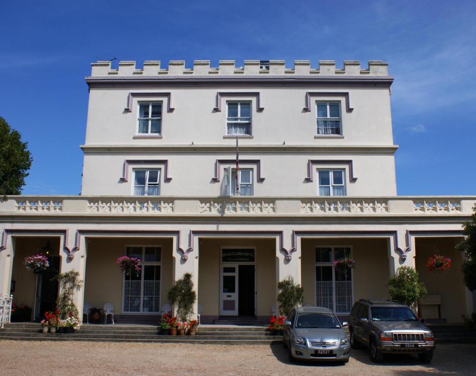 um edifício branco com carros estacionados em frente em Grange Lodge Hotel em Saint Peter Port