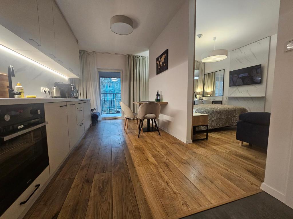 a living room with a kitchen and a dining room at City Sense - Brand New Apartment Close to the City Center and Main Station in Wrocław