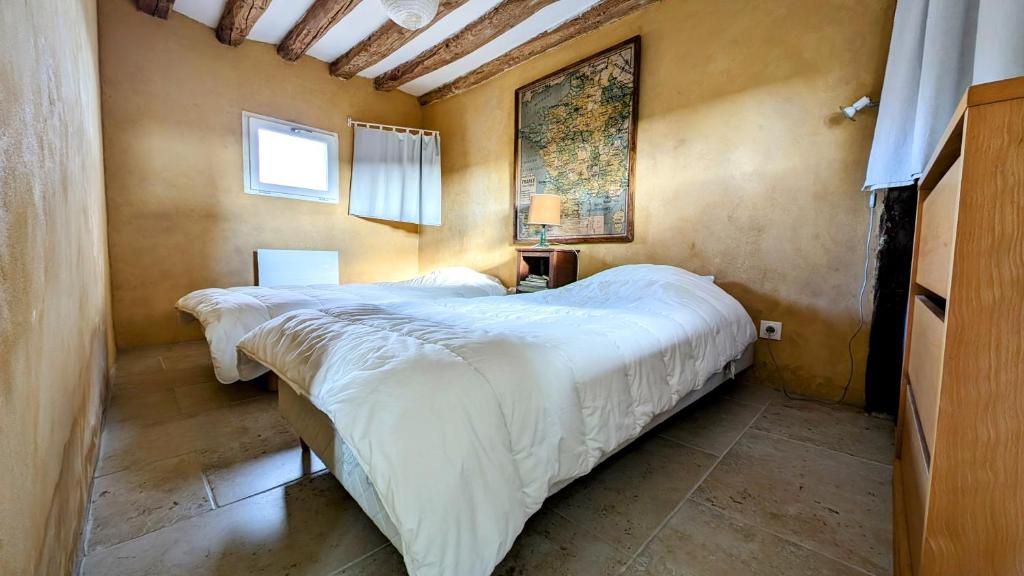 1 dormitorio con 2 camas y un cuadro en la pared en Sainte Suzanne gite de LA CHARRETERIE, en Les Baux-de-Breteuil