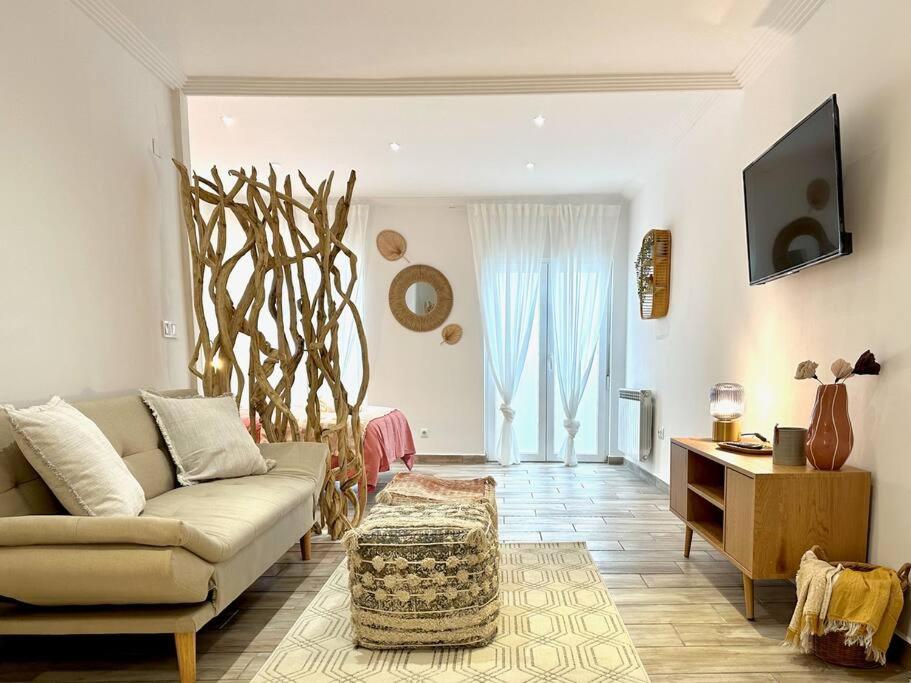 a living room with a couch and a tv at Estudio con encanto en el casco, junto al puerto in Castro-Urdiales