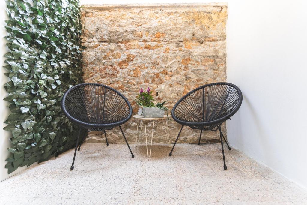 dos sillas sentadas junto a una mesa con una planta en Kanevaro 2 Chania Old Town, en La Canea