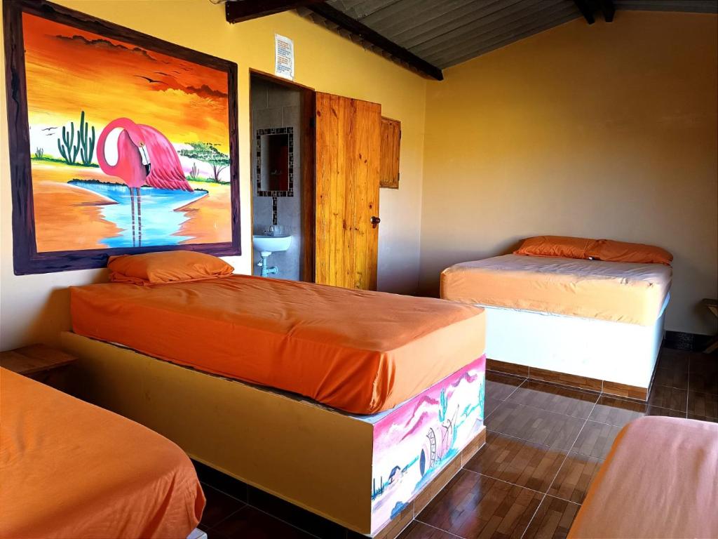- 2 lits dans une chambre ornée d'une peinture murale dans l'établissement EL KACHI Hospedaje y Restaurante, à Uribia