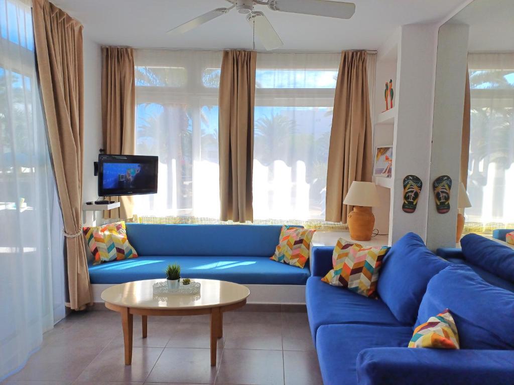 a living room with a blue couch and a table at Happy Heart Los Molinos in Costa Teguise